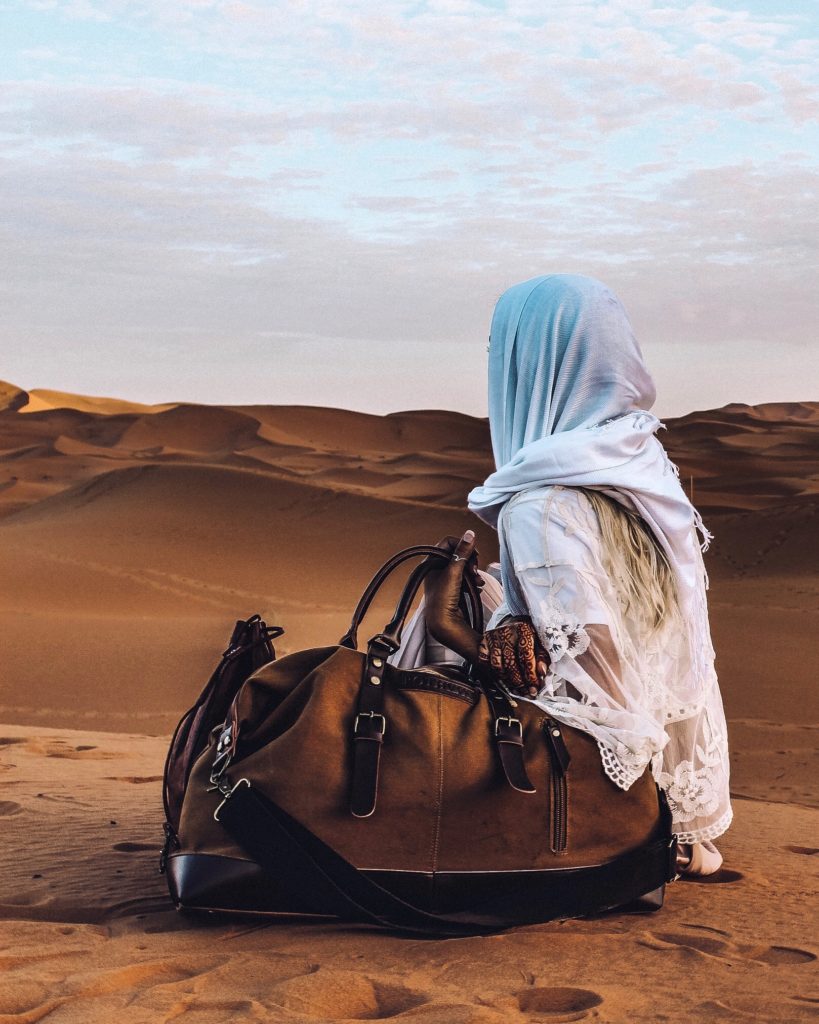 carry on bag with girl in sahara desert
