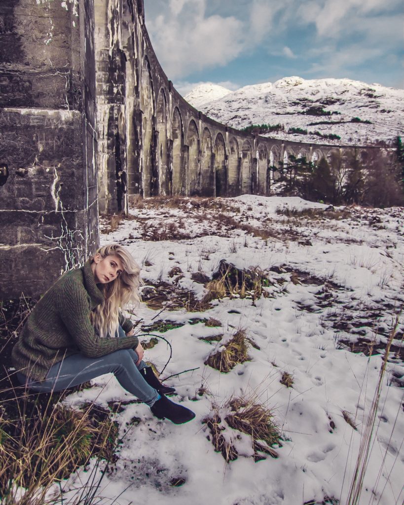girl dressed like a badass slytherin by the glenfinnan viaduct in scotland